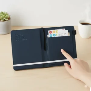 Detail view of the practical features of the small planner 2026, including the elastic closure, pen loop, and inner back pocket.