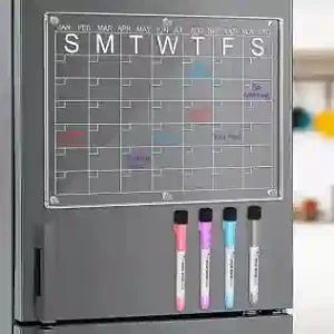 "Close up view of dry erase calendars magnetic refrigerator grid layout filled out with weekly tasks."